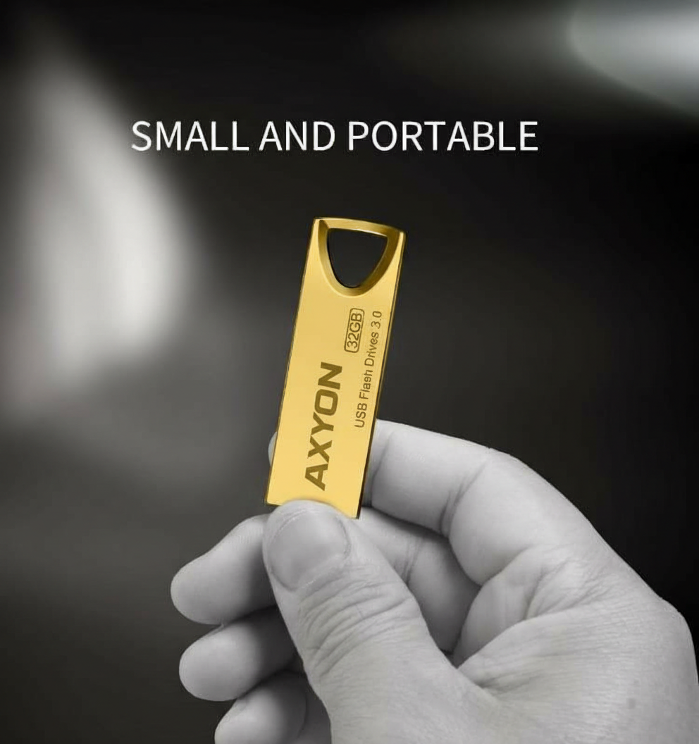 Gold USB flash drive held in a hand with 'AXYON' branding against a dark background.