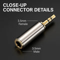 Close-up of a 3.5mm audio connector with labeled male and female ends on a dark background.