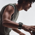 Man wearing a black AXYON Alpine Loop-style nylon watch band on an Apple Watch during a workout.