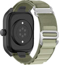 An olive green tactical nylon watch band with silver metal hardware, shown attached to a black smartwatch on a plain white background.