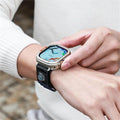 Smartwatch on a wrist with a colorful display, worn by a person.