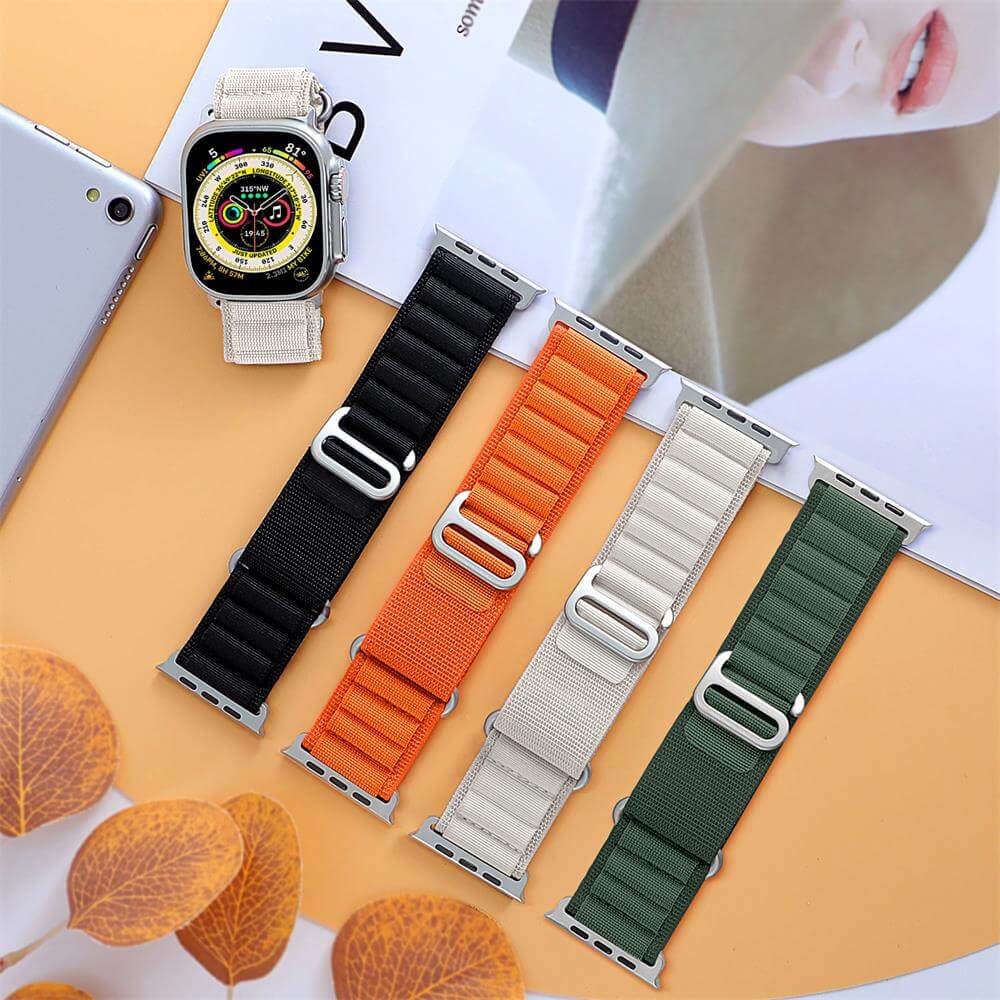 Two Apple Watches with Orange and Green Alpine Loop‑Style Bands – Durable woven nylon straps for sport and adventure.