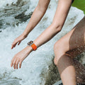 Apple Watch in Water with Orange Alpine Loop‑Style Band – Waterproof woven nylon strap for active lifestyles.