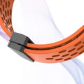 Close-up of an orange perforated band with a black clasp on a white background