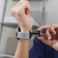 Person adjusting a smartwatch on their wrist with a blurred background