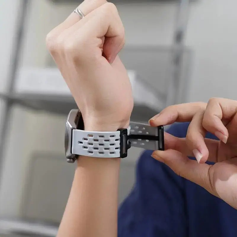 Person adjusting a smartwatch on their wrist with a blurred background