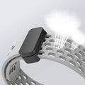 Close-up of a metallic bracelet with a black clasp on a light gray background