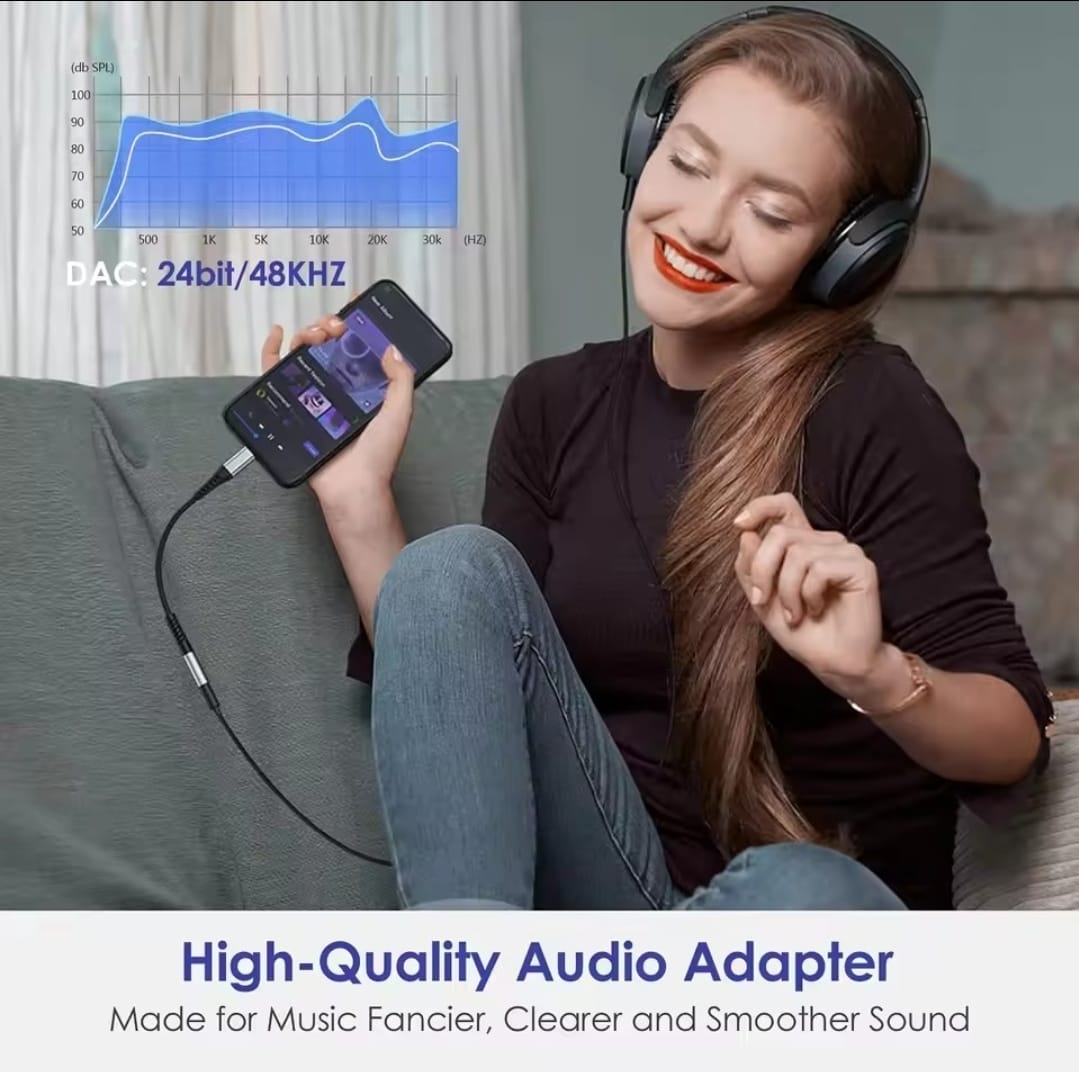 Woman using a high-quality audio adapter with her phone and headphones, sitting on a couch.
