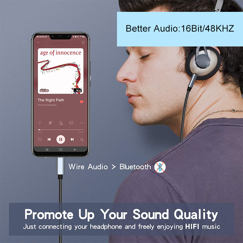 Person wearing headphones with a smartphone displaying music app on a gray background