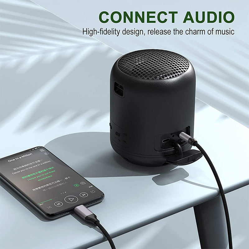Black portable speaker connected to a smartphone on a light gray surface with 'Connect Audio' text above.