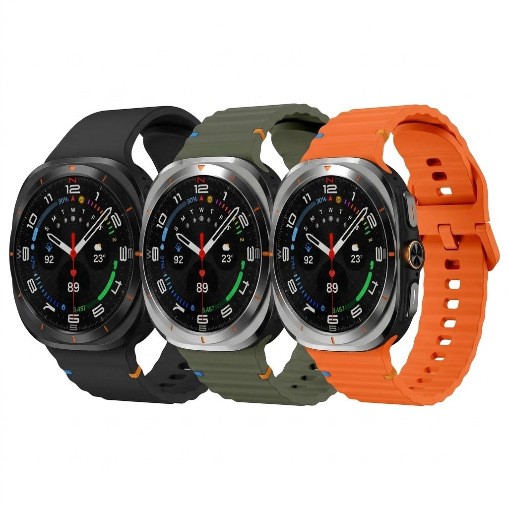 A product photo of three Samsung Galaxy Watch Ultras lined up on a plain white background, each with a different colored silicone band (matte black, army green, and bright orange).
